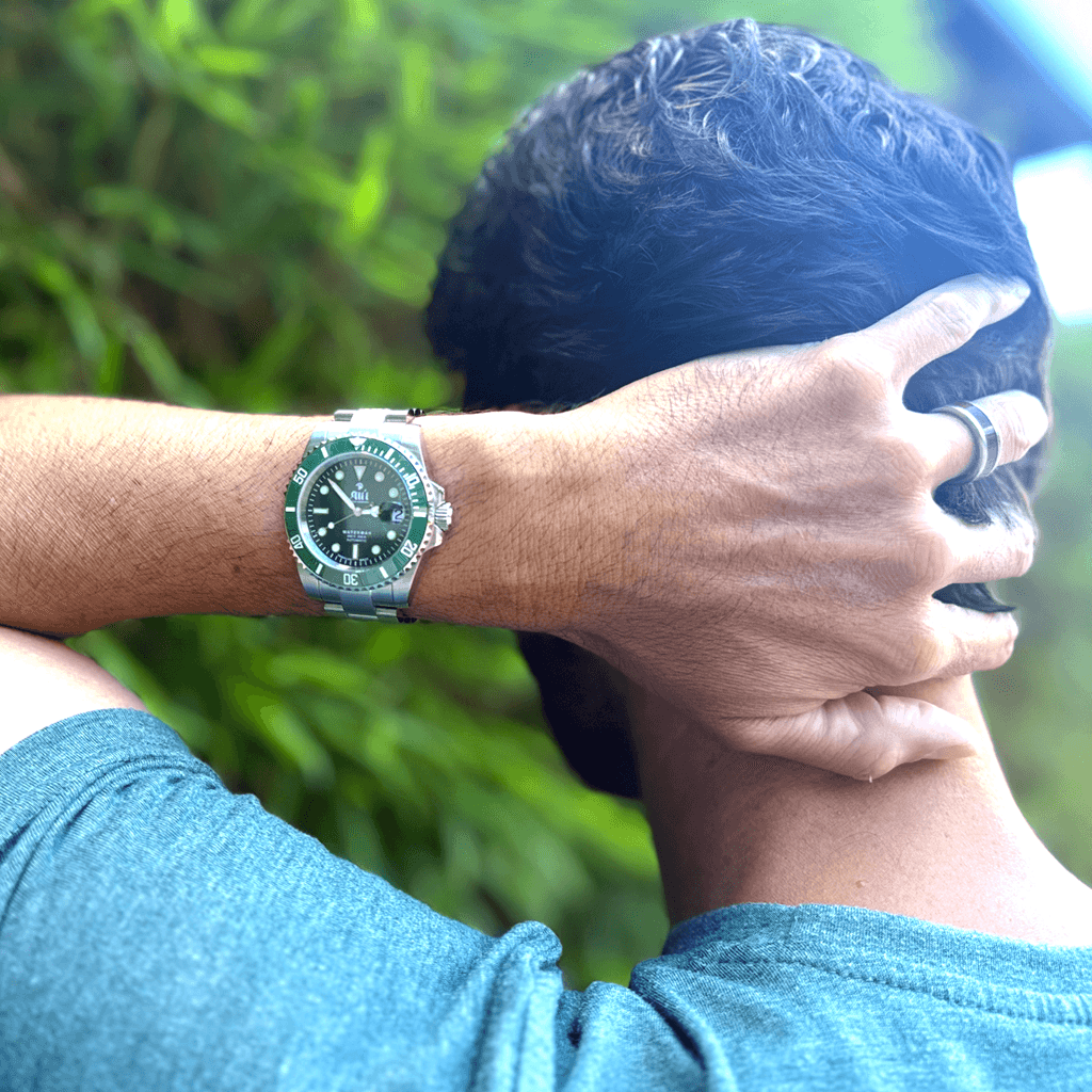 Ali’i Watch Company Waterman Green on a man’s wrist in front of bamboo.