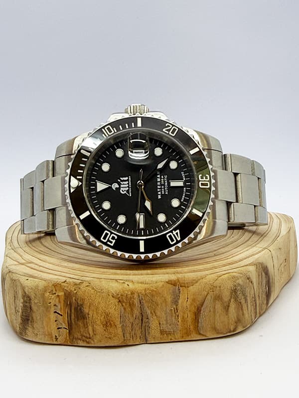 Ali'i Watch Company Waterman dive watch with a black dial and bezel sits on a piece of wood.